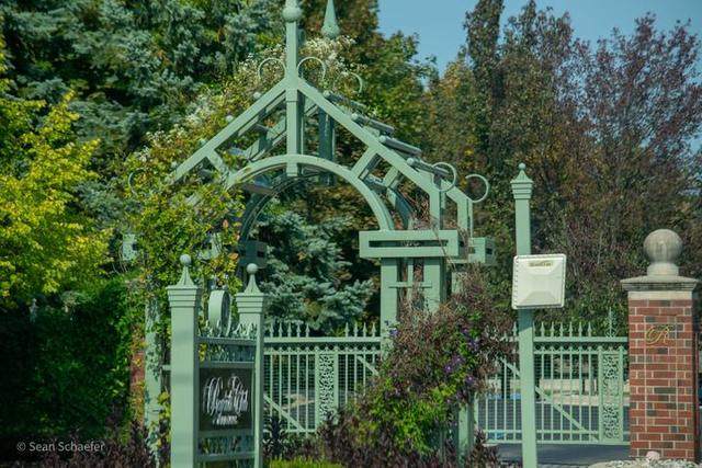 Steel pergola, sign, and driveway gate